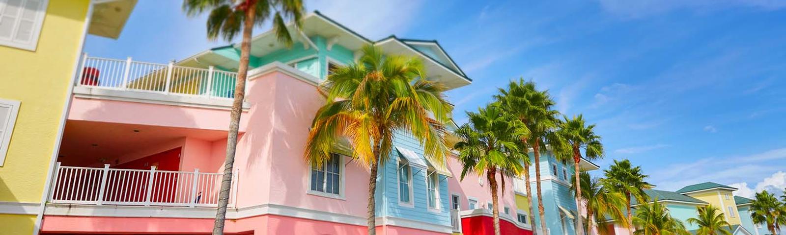 Colorful Caribbean-style buildings with palm trees under a bright blue sky.