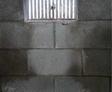 Cinder block wall with a vent, insulation on the floor beneath.