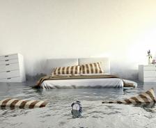 Bedroom with flooding water, a wet alarm clock, floating pillows, and half-submerged furniture.
