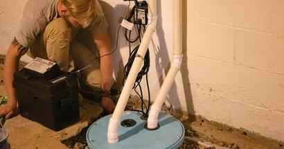Alpha crew member installing sump pump.
