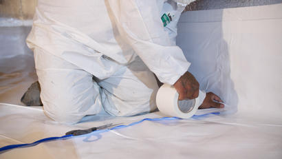Alpha crew member installing crawl space vapor barrier.