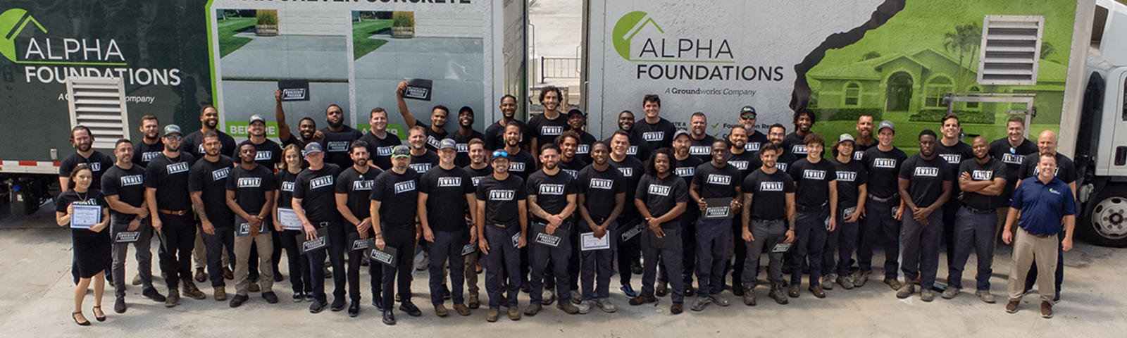 Alpha Foundations employees standing in front of box trucks