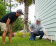 CFI Pointing at foundation while speaking with homeowner.