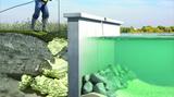 Worker applies foam to soil near a retaining wall by water, showing erosion control and wall stabilization.