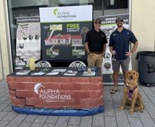 Alpha Foundations employees standing with a dog at a company booth at Pupchella 2026