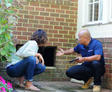 CFI speaking to homeowner while pointing at crawl space door opening.