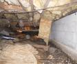 Crawl space with exposed insulation, ductwork, and a dirt floor.
