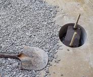 Close-up of Slab piers and shovel on gravel.