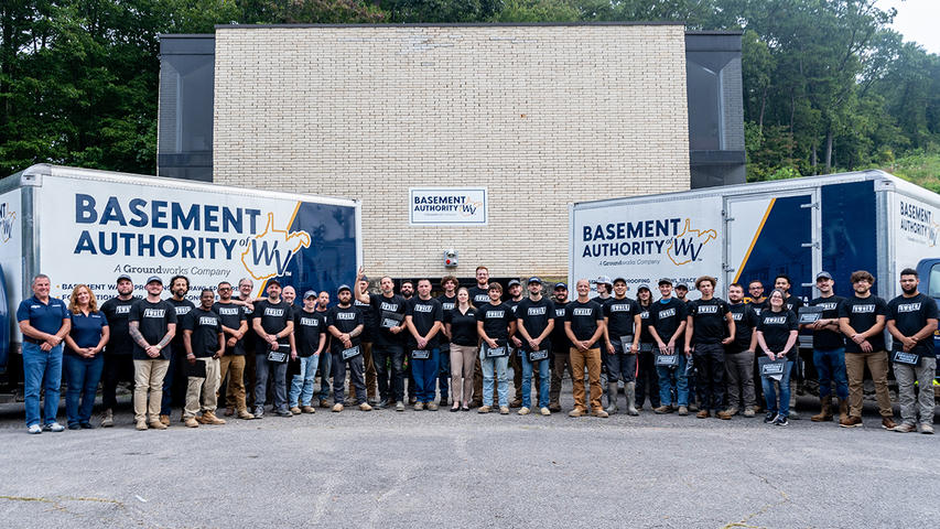Basement Authority of West Virginia employees in front of BAWV box trucks.
