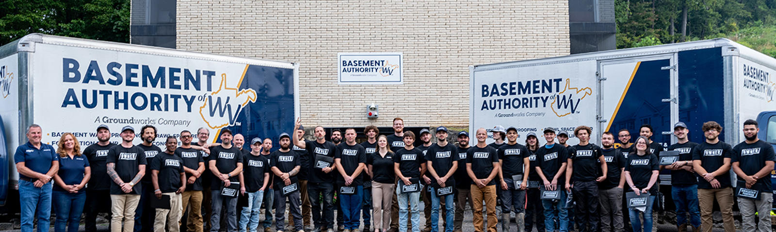 Basement Authority of West Virginia employees in front of BAWV box trucks.