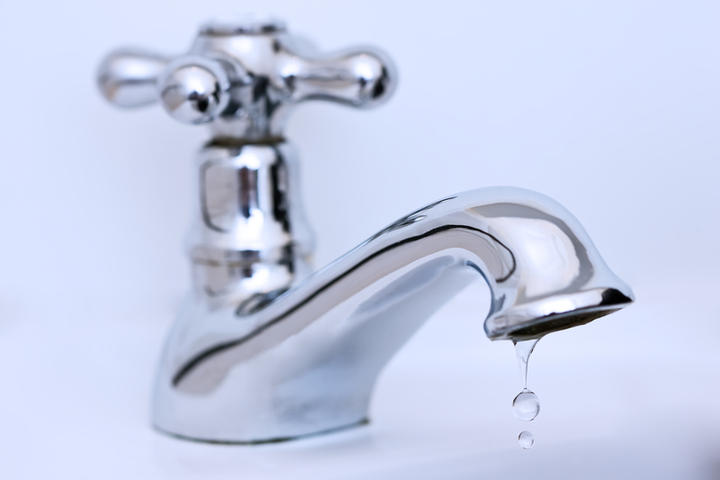 The faucet is dripping water, close up.