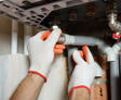 Hands checking pipes under the sink. close up
