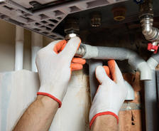 Hands checking pipes under the sink. close up