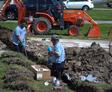 A1 technicians digging pipe line in yard