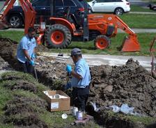 A1 technicians digging pipe line in yard