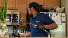 A1 employee fixing faucet plumbing.