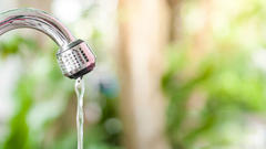 Closeup of faucet with running water.