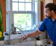 A1 technician checking water in kitchen sink.