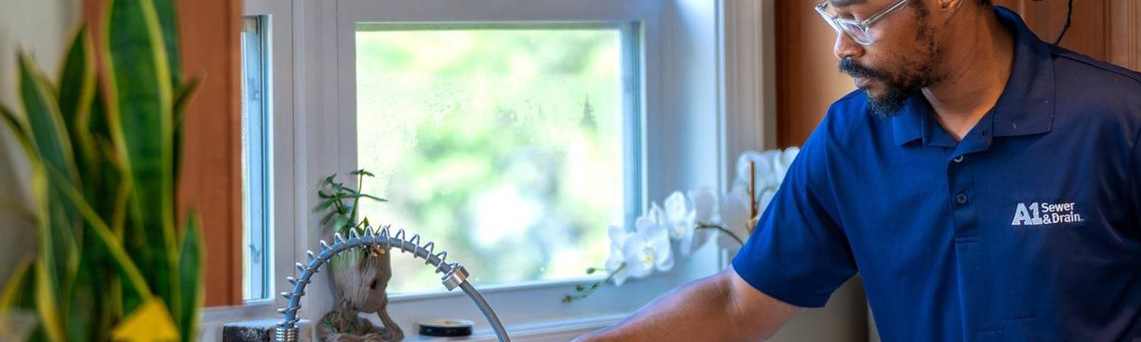 A1 technician checking water in kitchen sink.