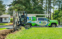 A1 Technician digging in front yard with A1 truck in the background.