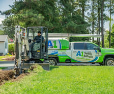 A1 Technician digging in front yard with A1 truck in the background.