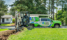 A1 Technician digging in front yard with A1 truck in the background.