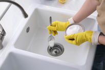 Woman Using Baking Soda Unclog Sink
