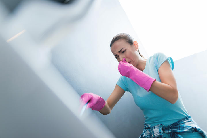 Woman with gloves plunging and holding noise.