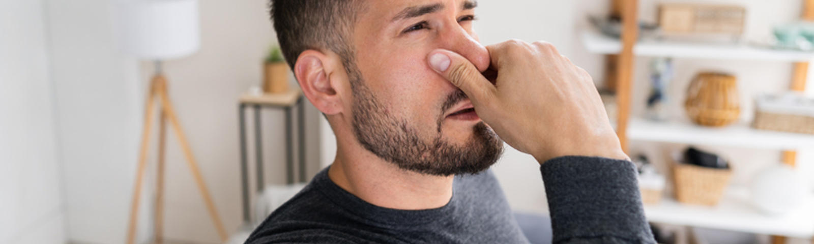 A man hold nose due to bad smell.