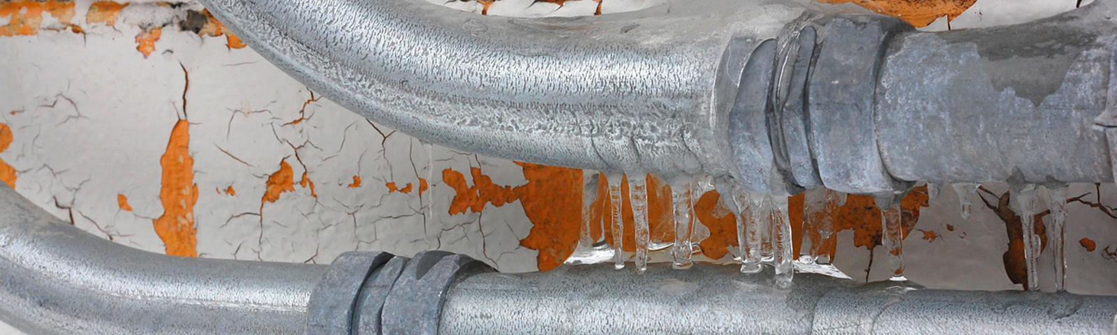 Frozen pipes with icicles close up.