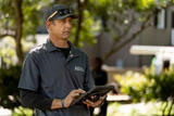 A1 employee looking at yard holding a tablet.