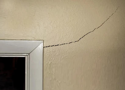 A corner crack next to a door frame in a home.