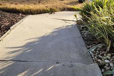 An uneven sidewalk on the exterior of a home.
