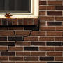 Cracked exterior brick wall under window.
