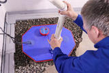 Man installing a quiet sump pump at the lowest point in the home