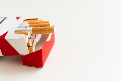 Open pack of cigarettes with several cigarettes partially pulled out against a white background.