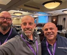 Three smiling Groundworks Canada team members wearing conference lanyards pose for a selfie in a meeting room at BBB Bootcamp sponsorship 2026.