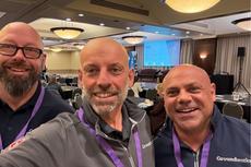 Three smiling Groundworks Canada team members wearing conference lanyards pose for a selfie in a meeting room at BBB Bootcamp sponsorship 2026.