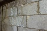 Close-up of a weathered concrete block wall with visible stains and texture.