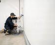 crew installing basement waterproofing sump pump