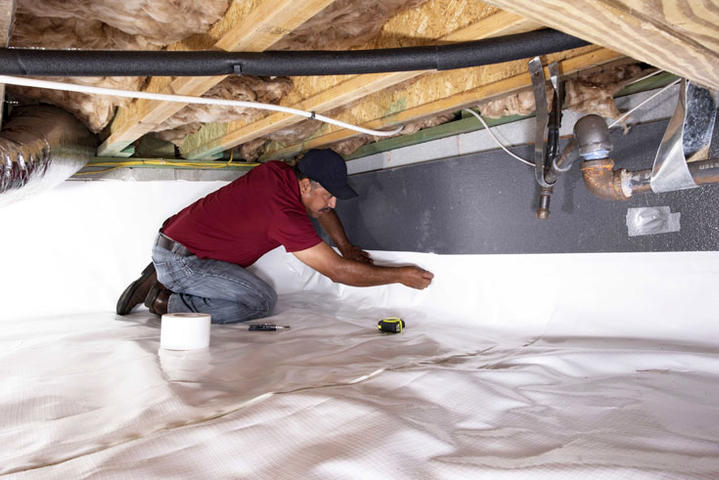CFI installing vapor barrier in crawlspace.
