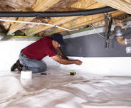 CFI installing vapor barrier in crawlspace.