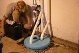 The crew is installing a sump pump and backup battery.