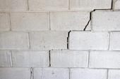 Cracks causing gap on cinderblock basement wall.