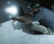 Crew installing a vapor barrier on crawlspace wall.