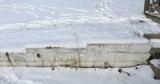 Cinderblock wall and stairs covered in snow.