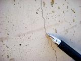 Pen showing a hairline crack in the concrete.