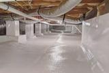 A clean, sealed crawl space with white vapor barrier sheets and ductwork visible overhead.