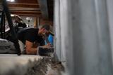 Crew installing full basement waterproofing and wall repair