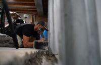 Crew installing full basement waterproofing and wall repair